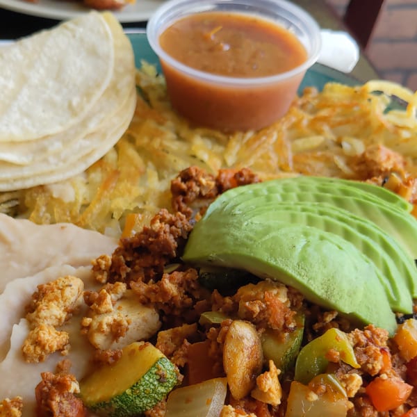 Aunt Yese's Home Cooking breakfast plate with hash browns, tortillas, salsa, avocado, and a scramble.