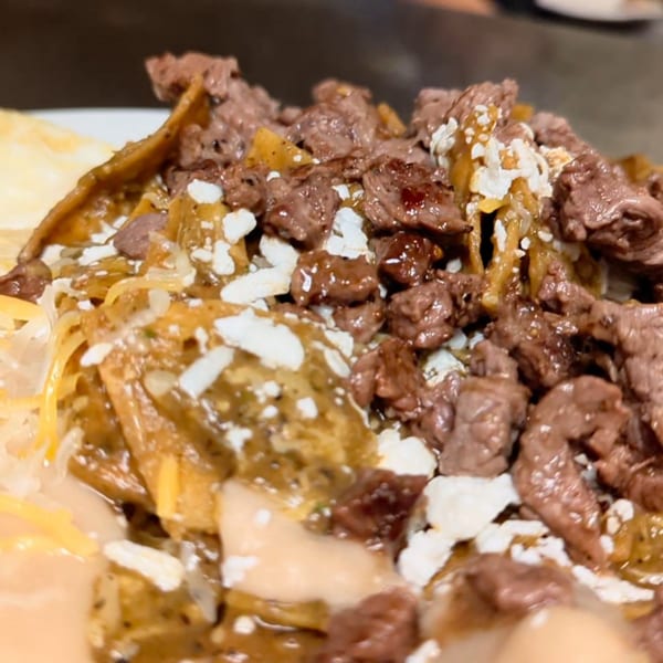 Close-up of chilaquiles with steak, cheese, and sauce, from Aunt Yese's Home Cooking.