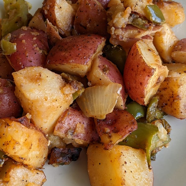 Close-up of Aunt Yese's Home Cooking's seasoned red and white potatoes with green peppers and onions.